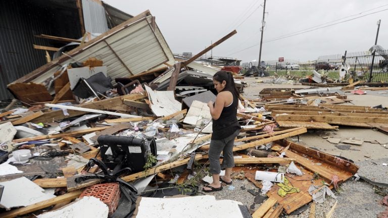 Jennifer Bryant looks over the debris from her family business destroyed by Hurricane Harvey Saturday, smashing homes and businesses and lashing the shore with wind and rain so intense that drivers were forced off the road because they could not see in front of them. (David J. Phillip/AP Photo)