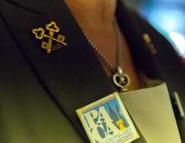 Fran Nachman wears crossed gold keys on her lapel, a symbol of her membership to Les Clefs d’Or, an international organization of professional hotel concierges. (Lindsay Lazarski/WHYY)