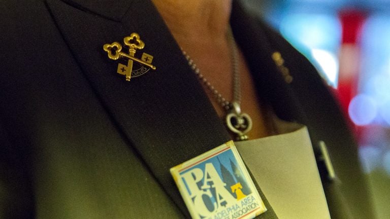 Fran Nachman wears crossed gold keys on her lapel, a symbol of her membership to Les Clefs d’Or, an international organization of professional hotel concierges. (Lindsay Lazarski/WHYY)