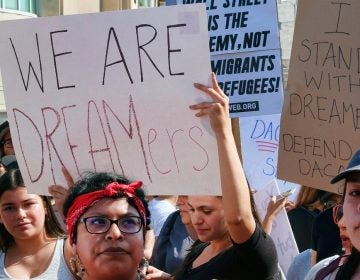 Supporters of the Deferred Action for Childhood Arrivals, or DACA chant slogans and hold signs while joining a Labor Day rally in downtown Los Angeles on Monday, Sept. 4, 2017.