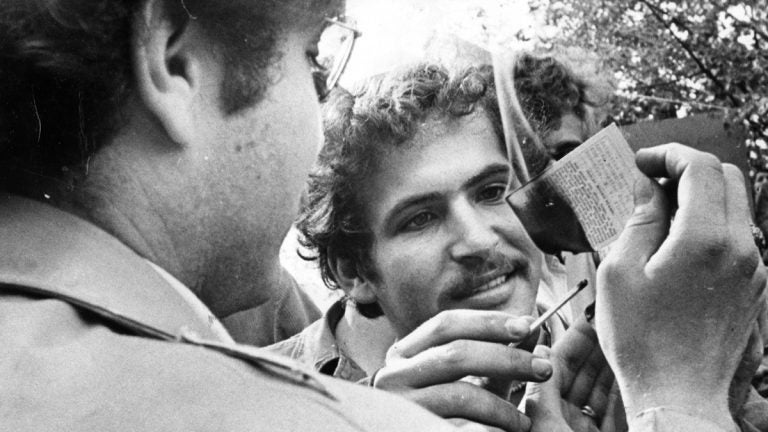 Two men are shown burning draft cards at a Jan 31, 1977, rally at J.F.K. Plaza. (Joseph Wasko / Courtesy of George D. McDowell Philadelphia Evening Bulletin Collection, Temple University Libraries)