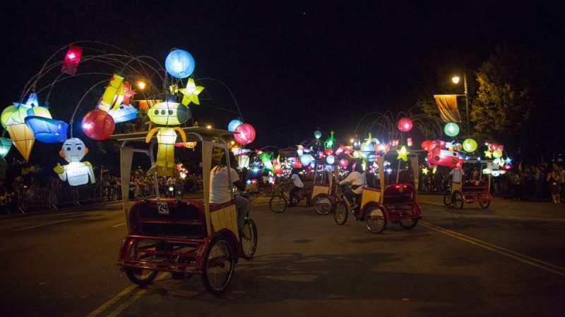 Pedicabs adorned with colorful lanterns perform a dance on the Ben Franklin Parkway to kick off the 100th anniversary of the Parkway. (Emily Cohen for NewsWorks)