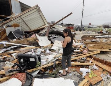  Jennifer Bryant looks over the debris from her family business destroyed by Hurricane Harvey Saturday, Aug. 26, 2017, in Katy, Texas. Harvey rolled over the Texas Gulf Coast on Saturday, smashing homes and businesses and lashing the shore with wind and rain so intense that drivers were forced off the road because they could not see in front of them. (AP Photo/David J. Phillip) 
