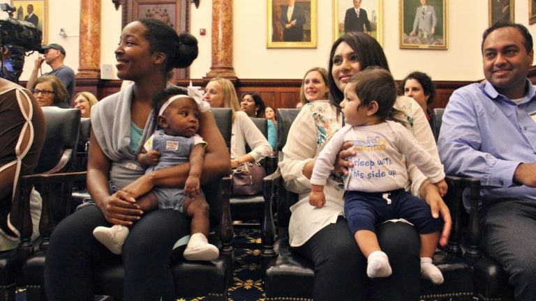 Nine-month-old Aarav Vyas (right) wears a shirt with the slogan ''I sleep with this side up.'' He and his mother, Aasta Mehta, along with Jasmine Pitt-Mitchell and her 6-month-daughter, Leilani (left) helped to kick off Philadelphia's safe sleeping campaign. (Emma Lee/WHYY)
