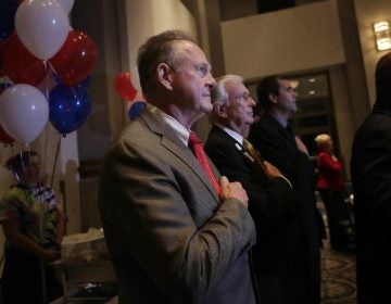 Former Alabama Chief Justice and U.S. Senate candidate Roy Moore, stops to say the Pledge of Allegiance as he walks around greeting supporters before his election party, Tuesday, Sept. 26, 2017, in Montgomery, Ala.