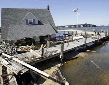 A home rests next to a pier in Barnegat Bay in 2013 near the Mantoloking Bridge in Mantoloking, N.J., after it was swept away by Superstorm Sandy. (Mel Evans/AP Photo)