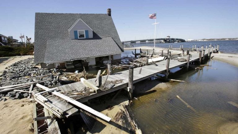 A home rests next to a pier in Barnegat Bay in 2013 near the Mantoloking Bridge in Mantoloking, N.J., after it was swept away by Superstorm Sandy. (Mel Evans/AP Photo)