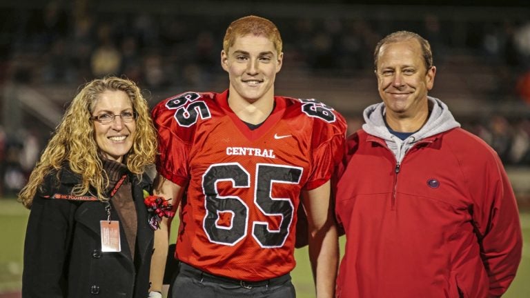   This Oct. 31, 2014, photo provided by Patrick Carns shows Timothy Piazza, (center), with his parents Evelyn and James Piazza, during Hunterdon Central Regional High School football's 'Senior Night' at the high school's stadium in Flemington, N.J. (Patrick Carns via AP)  