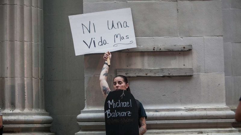 Ashley Babiarz of Northeast Philadelphia holds a sign to honor her brother Michael who died in 2011 of an overdose. (Brad Larrison for NewsWorks)