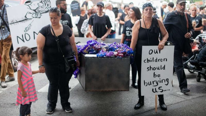 A casket is carried up Kensington Avenue Thursday during the March in Black in remembrance of those who have died of opioid overdoses in the Philadelphia region. (Brad Larrison for NewsWorks)