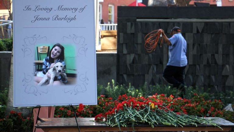 Carnations are piled beside a portrait of murder victim Jenna Burleigh after a memorial service at Temple University's Founder's Garden