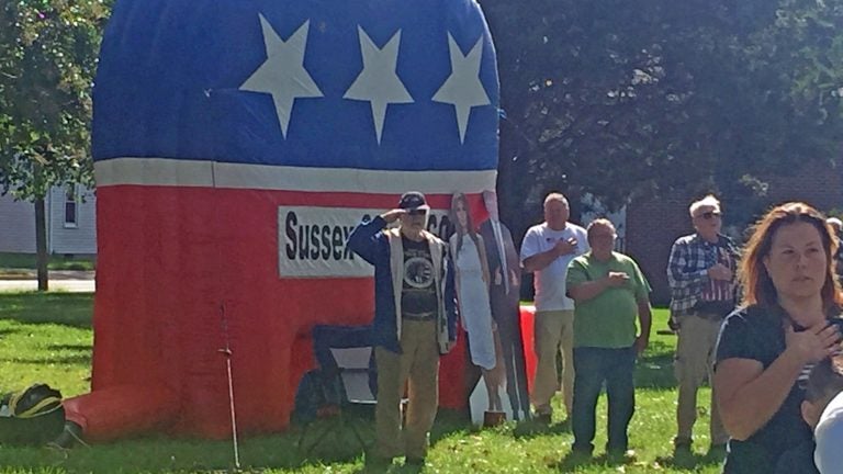 Some of the attendees at the pro-Trump rally in Georgetown on Saturday stand at attention while the National Anthem plays. (Cris Barrish/WHYY)