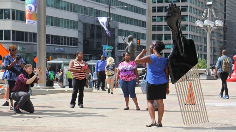 Frank Rizzo's statue  on the plaza of the Municipal Services Building stands at the center of controversy. Recently this afro pick with a black power symbol was added.(Emma Lee/WHYY)