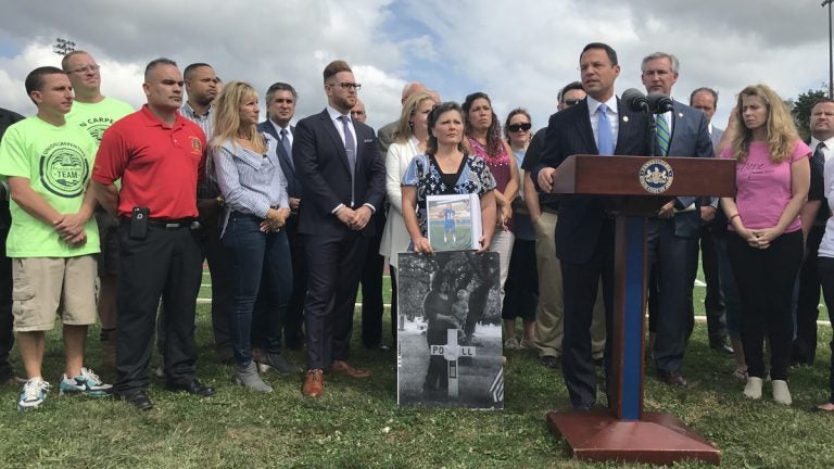 Pennsylvania Attorney General Josh Shapiro, flanked by people whose loved ones have been addicted to opioids, announces new details of a 41-state investigation into the role of pharmaceutical companies in the opioid epidemic. (Laura Banshoff/WHYY)