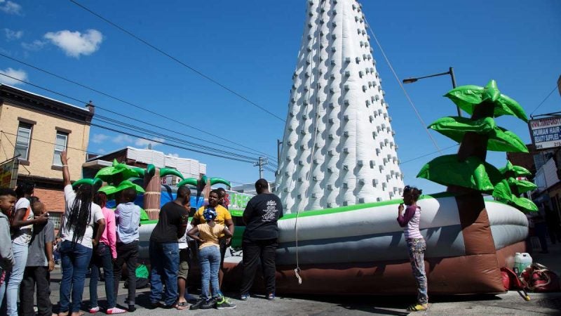 Children wait in line to attempt to reach the top of an inflatable rock-climbing wall during Southwest Pride Day festivities in Southwest Philadelphia. (Annie Risemberg for NewsWorks)