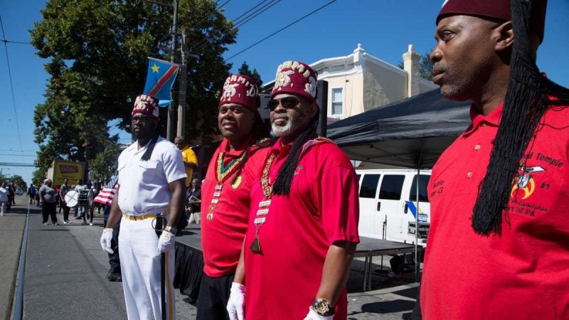 Members of the Pyramid Temple #1 look on as residents participate in Southwest Pride Day festivities on Woodland Avenue. (Annie Risemberg for NewsWorks)