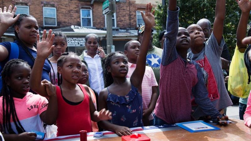 Children volunteer to be picked for a trick performed by a local magician. (Annie Risemberg for NewsWorks)