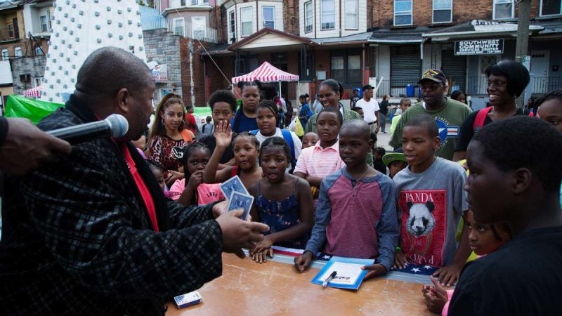 Children look on in awe as a magician completes a card trick in front of them. (Annie Risemberg for NewsWorks)