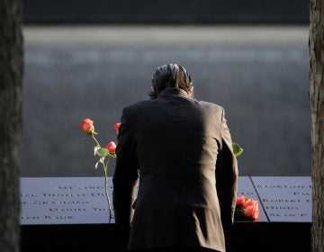  A man stands at the edge of a waterfall pool during a ceremony at ground zero in New York, Monday, Sept. 11, 2017. Holding photos and reading names of loved ones lost 16 years ago, 9/11 victims' relatives marked the anniversary of the attacks at ground zero on Monday with a solemn and personal ceremony. (AP Photo/Seth Wenig) 