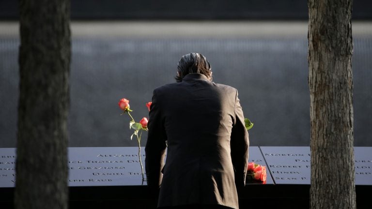  A man stands at the edge of a waterfall pool during a ceremony at ground zero in New York, Monday, Sept. 11, 2017. Holding photos and reading names of loved ones lost 16 years ago, 9/11 victims' relatives marked the anniversary of the attacks at ground zero on Monday with a solemn and personal ceremony. (AP Photo/Seth Wenig) 