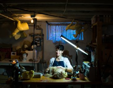 Beth Beverly works in her studio where she makes hats, jewelry and home decor items with parts of dead animals. (Paige Pfleger/WHYY)