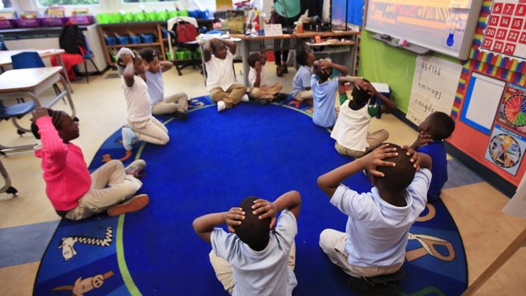 An elementary school teacher instructs students to put their hands over their heads. (AP File Photo/Manuel Balce Ceneta)