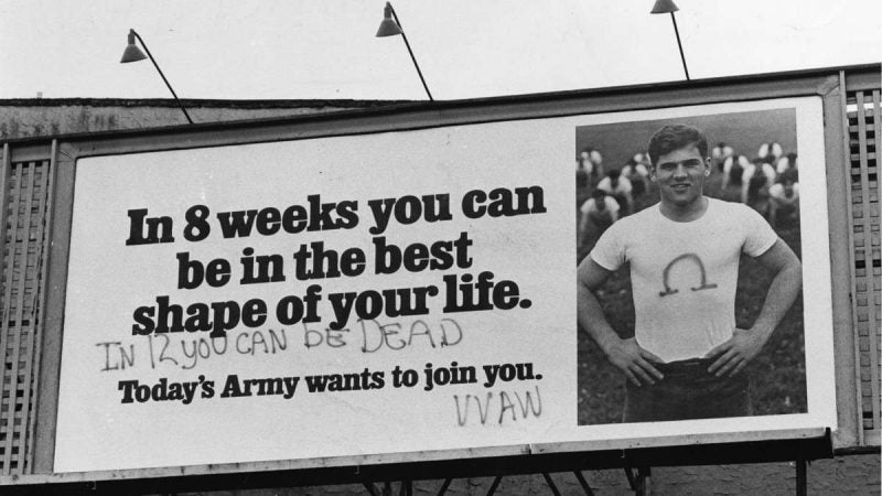 Graffiti is shown sprayed on a U.S. Army billboard at 34th and Walnut Streets on June 17, 1972. The graffiti artists sprayed the Greek letter omega, which is the symbol of a group of draft resisters, on the t-shirt worn by the man photographed. (Joshua Bernstein / Courtesy of George D. McDowell Philadelphia Evening Bulletin Collection, Temple University Libraries)