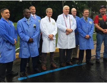 Inaugural class of the Odessa Center for Horological Excellence (Students in blue lab coats; Rick Aubin, instructor, and Sam Cannan, founder, both in white; Michael Wipf, president of Hogs and Heroes' Middletown chapter) (Shirley Min/WHYY) 