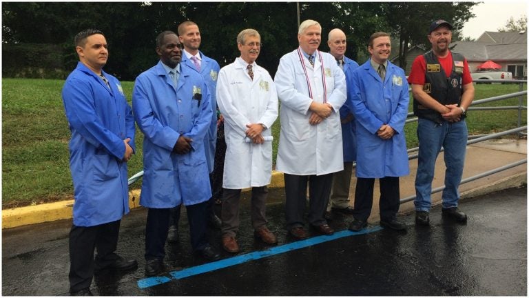 Inaugural class of the Odessa Center for Horological Excellence (Students in blue lab coats; Rick Aubin, instructor, and Sam Cannan, founder, both in white; Michael Wipf, president of Hogs and Heroes' Middletown chapter) (Shirley Min/WHYY) 