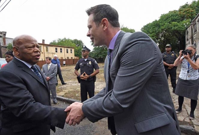 Activist Patrick Duff shakes hands with Rep. John Lewis at the September 2016 press conference in front of the Walnut Street home where Martin Luther King, Jr. spent time as a seminary student.  (April Saul/for WHYY)