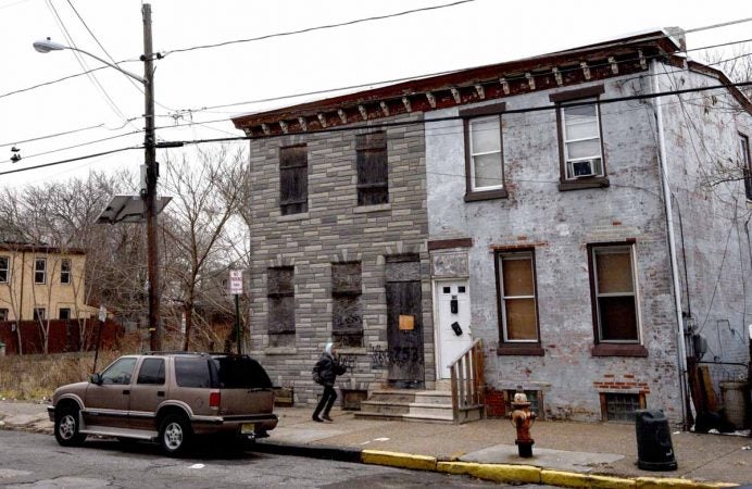 At left; the rowhouse with boarded-up windows at 753 Walnut Street where Martin Luther King, Jr. spent time as a seminary student.  (April Saul/for WHYY)