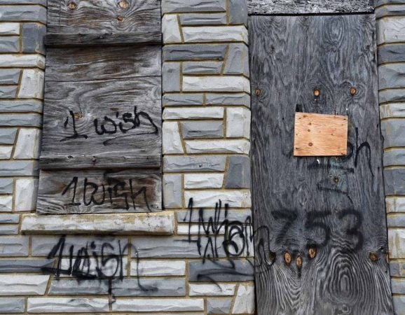 Graffiti on the front of the house at 753 Walnut Street in Camden where Martin Luther King, Jr. stayed as a seminary student before it was removed for a September 2016 press conference.  (April Saul/for WHYY)