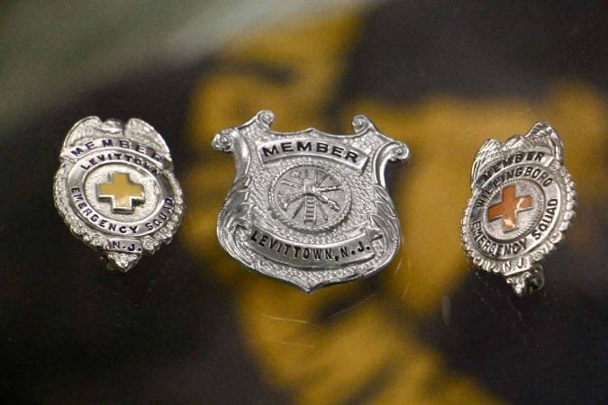 Badges worn by the Levittown Emergency Squad are on display at the Willingboro Public Library. (Emma Lee/WHYY)