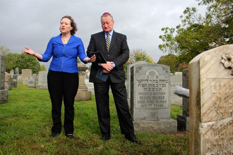 Naomi Adler, CEO of the Jewish Federation of Greater Philadelphia, sings a prayer during a visit to Mt. Carmel Cemetery with Mayor Jim Kenney, who toured the site to see the repairs made to vandalized tombstones