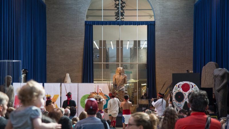 Revelers watch the Ollin Papalota Group as they perform traditional Aztec dances at Penn Museum's annual Day of the Dead celebration