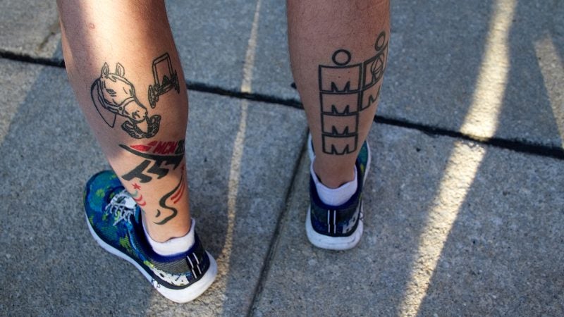 Tattoos remind Kevin Peter of the races he ran. Finished marathons, including three in Philadelphia adorn the left calf and finished Iron Man triathlons are on the right. (Bastiaan Slabbers for WHYY)