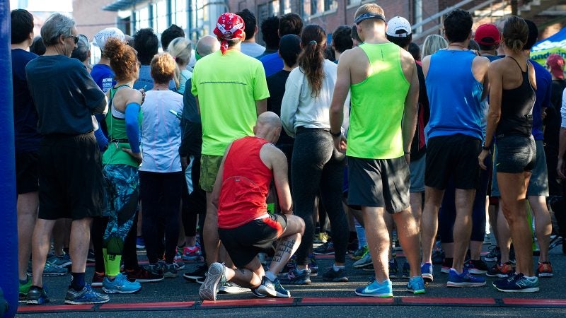 Kevin Peter, of West Mt. Airy, takes a knee in protest during the National Anthem at the start of the WXPN 5K, on Sunday. (Bastiaan Slabbers for WHYY)