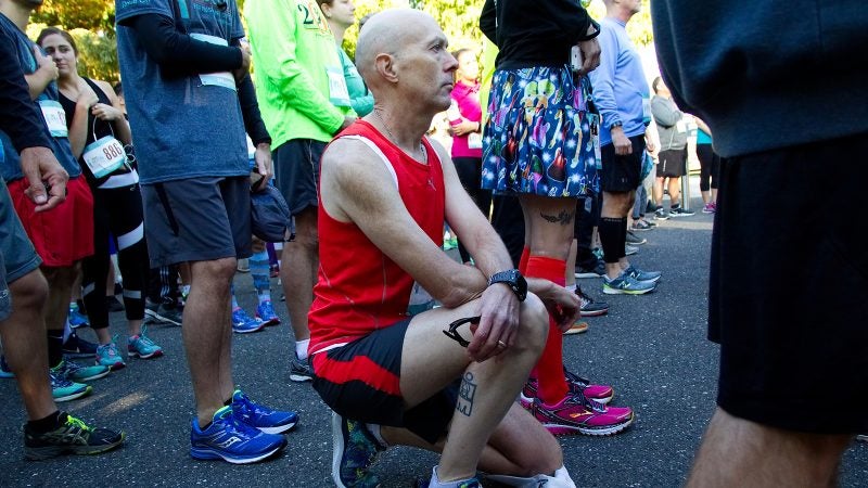 Kevin Peter, of West Mt. Airy, takes a knee in protest during the National Anthem at the start of the WXPN 5K, on Sunday. (Bastiaan Slabbers for WHYY)