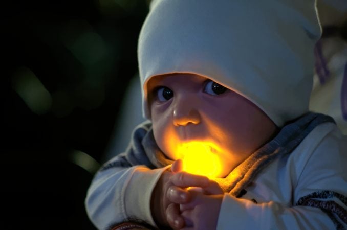 Five-month-old Paxton Perrone holds a battery operated candle at the Regional Candlelight Vigil fro victims of addiction at Camden Waterfront Stadium on October 14, 2017. (Bastiaan Slabbers for WHYY)