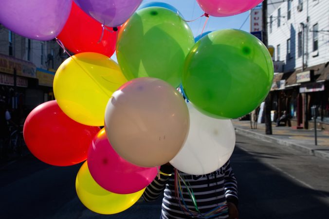 Balloons obscure the face of a girl as she crosses the street during Philly Free Streets event, Saturday, Oct. 28, 2017. (Bastiaan Slabbers for WHYY)