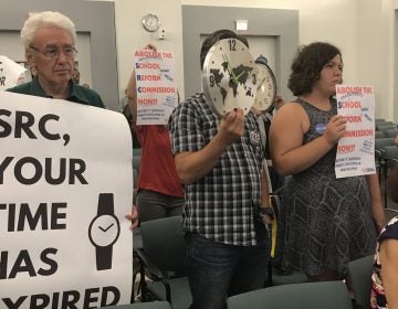 Protesters including retired teacher Ron Whitehorne (left) at a recent School Reform Commission meeting demanded that the body vote to dissolve itself and return the Philadelphia School District to local control.