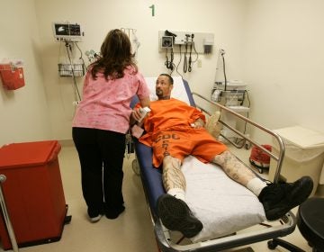 A registered nurse treats an inmate at San Quentin State Prison