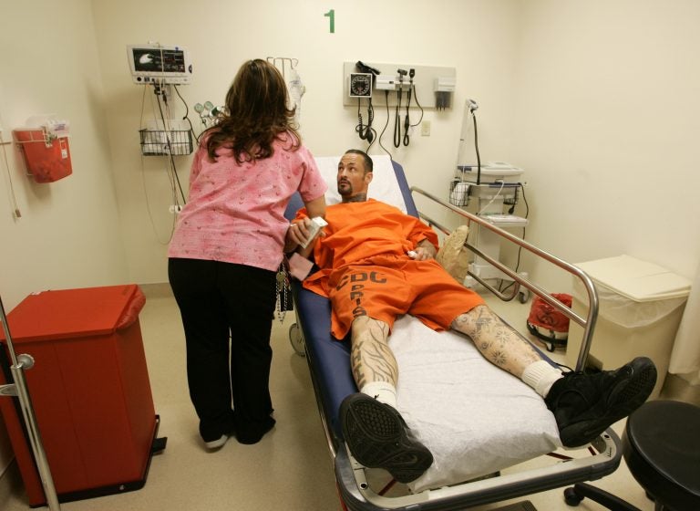 A registered nurse treats an inmate at San Quentin State Prison