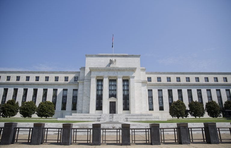 The Federal Reserve Building; white columns, black fencing against a blue sky