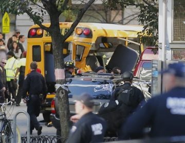 Authorities respond near a damaged school bus Tuesday, Oct. 31, 2017, in New York. A motorist drove onto a busy bicycle path near the World Trade Center memorial and struck several people on Tuesday police and witnesses said.