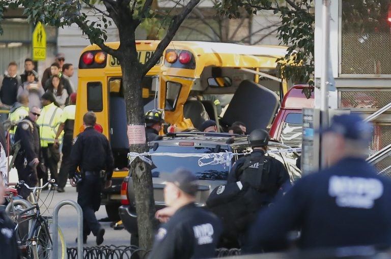 Authorities respond near a damaged school bus Tuesday, Oct. 31, 2017, in New York. A motorist drove onto a busy bicycle path near the World Trade Center memorial and struck several people on Tuesday police and witnesses said.