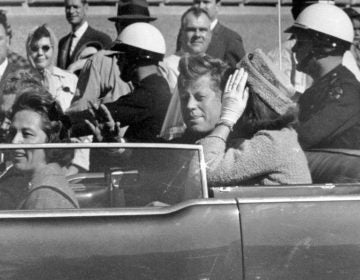 Black and white photo of Mr. and Mrs. JFK in the limousine, moments before the assassination