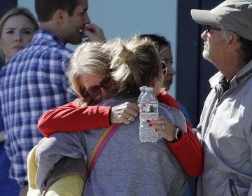 Two women embrace outside of a family assistance center