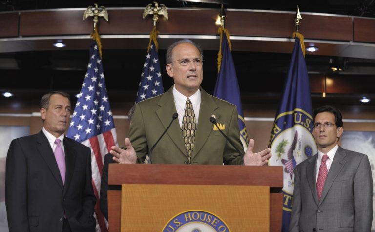 Man in an olive suit at podium