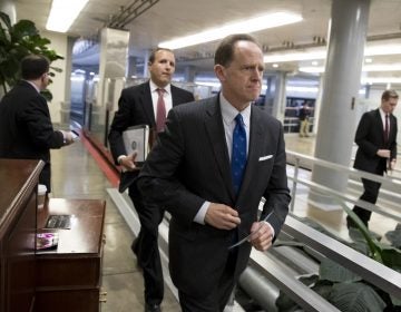 Toomey walks through a hallway in the Capitol